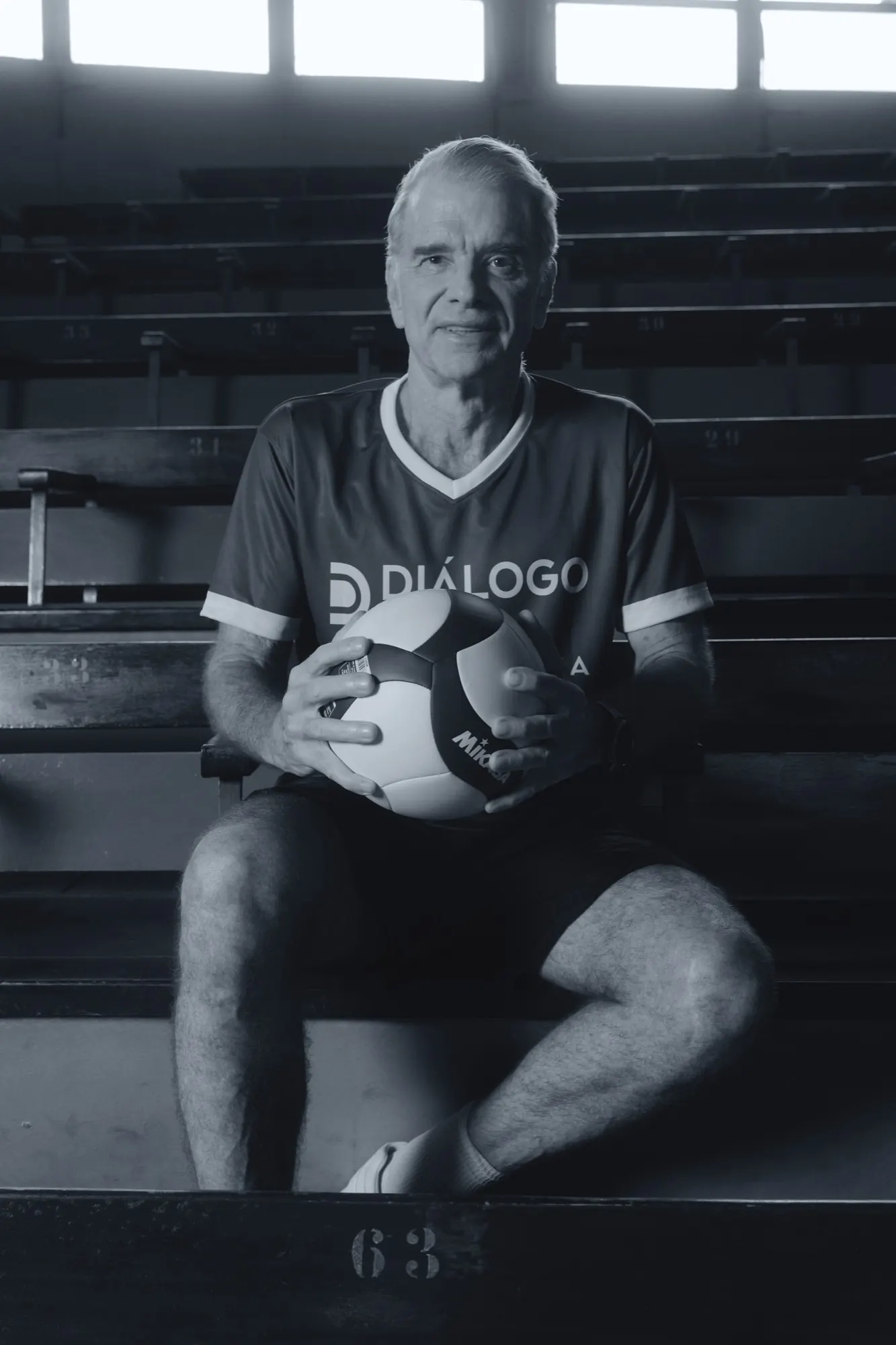 Bernardinho segurando uma bola de vôlei na arquibancada