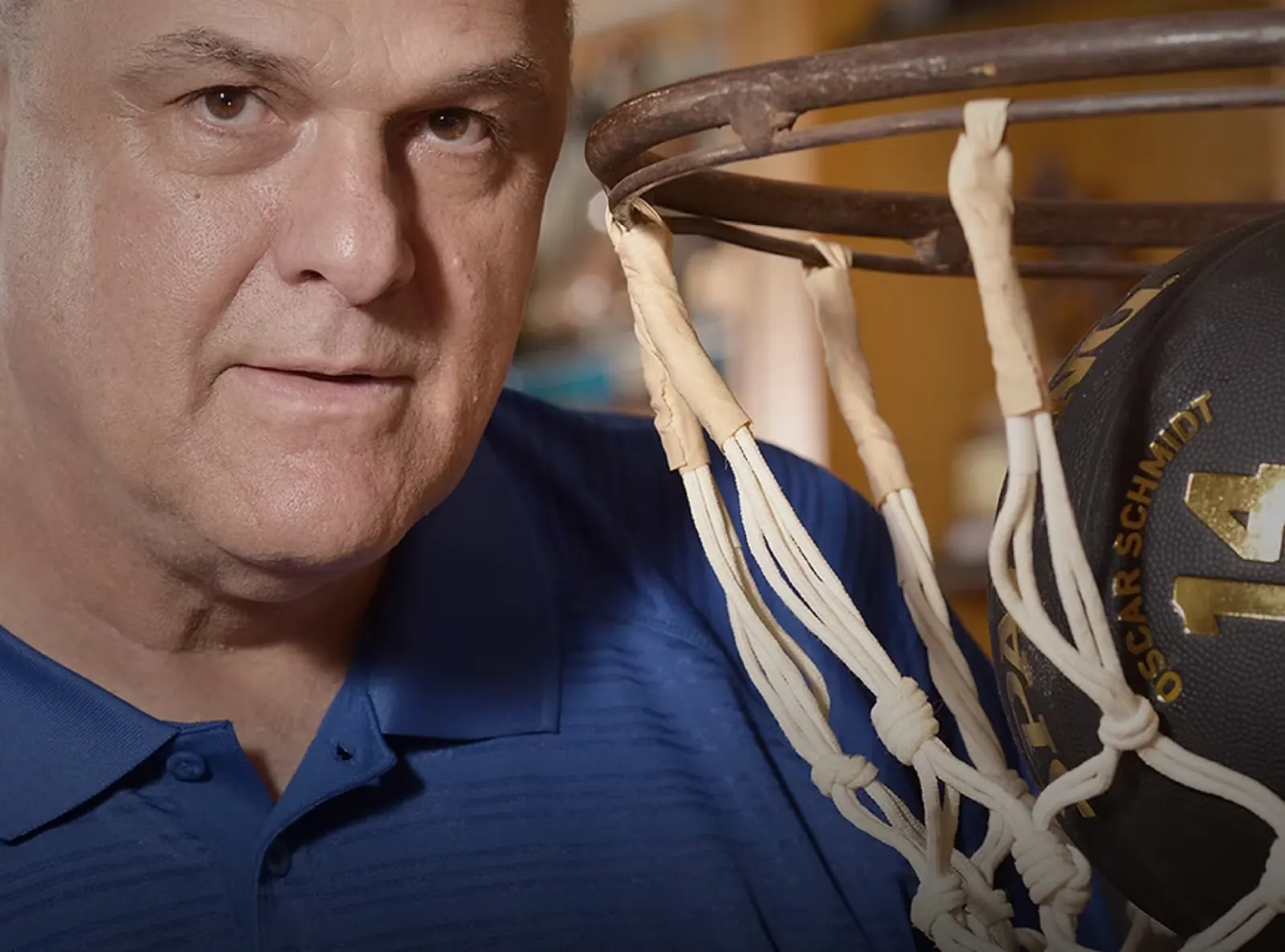 Retrato de Oscar Schmidt ao lado de uma cesta de basquete